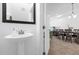 Powder room with pedestal sink and view to dining area at 8110 Roseville Rd, Davenport, FL 33896