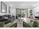 Bright living room with gray sofas, green chairs, and sliding glass doors at 8110 Roseville Rd, Davenport, FL 33896