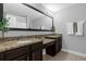 Double vanity bathroom with granite countertops and dark wood cabinets at 8110 Roseville Rd, Davenport, FL 33896