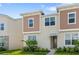 Two-story townhome with light brown and beige siding at 2326 Zaballina Pl, Kissimmee, FL 34747