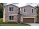 Two-story house with a gray and brown exterior and a brown garage door at 33239 Country House Dr, Sorrento, FL 32776