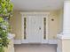 White front door with sidelights, leading into the home at 7502 Seven Eagles Way, Reunion, FL 34747