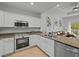Modern kitchen featuring white cabinets, stainless steel appliances, and granite countertops at 7502 Seven Eagles Way, Reunion, FL 34747