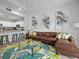 Living area featuring a brown sectional sofa, coffee table, and kitchen views at 7502 Seven Eagles Way, Reunion, FL 34747