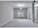 Bright dining room with neutral walls and carpet, featuring a large window and chandelier at 1042 Twisted Branch Ln, St Cloud, FL 34771