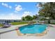 Inviting pool with a stone patio, lake view, and comfortable seating at 325 Magnolia St, Windermere, FL 34786