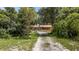Ranch-style home with long driveway, surrounded by lush greenery at 10611 Jim Edwards Rd, Haines City, FL 33844
