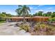Ranch-style home with stone facade, palm trees, and a spacious driveway at 10611 Jim Edwards Rd, Haines City, FL 33844