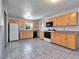 Bright kitchen featuring wood cabinets, tile floors, and modern appliances at 7685 Ceres Dr, Orlando, FL 32822