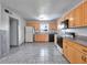 Bright kitchen featuring wood cabinets, tile floors, and modern appliances at 7685 Ceres Dr, Orlando, FL 32822