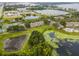 Aerial view of community near lake, featuring tennis courts and lush green spaces at 7524 Seurat St # 12301, Orlando, FL 32819