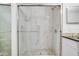 Modern shower with marble-look tile and glass enclosure at 7524 Seurat St # 12301, Orlando, FL 32819