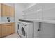 Bright laundry room with washer, dryer, and ample shelving at 6311 Chorus Dr, Mascotte, FL 34753