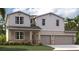 Two-story home with gray siding and two-car garage at 12970 Trovita Dr, Grand Island, FL 32735