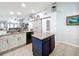 Modern kitchen with white cabinets, a large island, and a stylish barn door at 13333 Early Frost Cir, Orlando, FL 32828