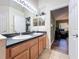 Double sink bathroom with dark countertop and wood cabinets at 13333 Early Frost Cir, Orlando, FL 32828