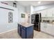 Stylish kitchen with white cabinets, granite countertops, and a navy blue island at 13333 Early Frost Cir, Orlando, FL 32828