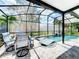 Inviting pool area with screened enclosure, lounge chairs, and dining table at 13333 Early Frost Cir, Orlando, FL 32828