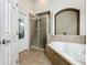 Clean bathroom featuring a shower, soaking tub and tile flooring at 13333 Early Frost Cir, Orlando, FL 32828