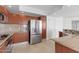 Modern kitchen with stainless steel refrigerator and wood cabinets at 231 Riverside Drive # 1209-1, Holly Hill, FL 32117