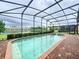Screened-in pool and spa with a view of a lake and community at 8829 Corcovado Dr, Kissimmee, FL 34747
