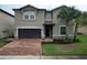 Two-story house with a two-car garage and a brick driveway at 8829 Corcovado Dr, Kissimmee, FL 34747