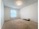 Well-lit bedroom with a window, carpet flooring, and a bench at 8829 Corcovado Dr, Kissimmee, FL 34747