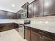 Modern kitchen with dark wood cabinets, granite countertops, and stainless steel appliances at 8829 Corcovado Dr, Kissimmee, FL 34747