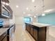 Modern kitchen with island, granite countertops and stainless steel appliances, open to Gathering room at 8829 Corcovado Dr, Kissimmee, FL 34747