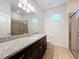Bathroom boasts granite countertop, dark brown vanity, and a walk-in shower at 8829 Corcovado Dr, Kissimmee, FL 34747