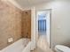 Clean bathroom with a bathtub and shower, and access to bedroom at 8829 Corcovado Dr, Kissimmee, FL 34747