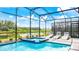 Luxury screened pool and spa with lake view and lounge chairs at 2965 Protagonist St, Kissimmee, FL 34746