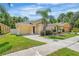 Single-story home with a yellow exterior, palm trees, and a driveway at 131 Sandy Ridge Dr, Davenport, FL 33896