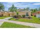 Single-story home with a yellow exterior, palm trees, and a driveway at 131 Sandy Ridge Dr, Davenport, FL 33896