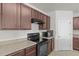 View of kitchen with dark cabinets, granite countertops and a black stove at 5716 Lakeside Landings Blvd, Winter Haven, FL 33881