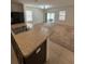 Kitchen island with sink and view into adjacent living room at 5716 Lakeside Landings Blvd, Winter Haven, FL 33881