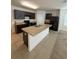 Kitchen features an island, dark cabinets, and granite countertops at 5716 Lakeside Landings Blvd, Winter Haven, FL 33881