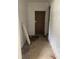View of hallway with brown door and worn flooring at 207 Robin Rd, Altamonte Springs, FL 32701
