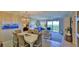 Light and airy dining area with a beautiful chandelier and seating for six at 5300 S Atlantic Ave # 16-602, New Smyrna Beach, FL 32169