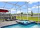 Relaxing screened pool and spa with patio chairs and umbrella at 9106 Sommerset Hills Dr, Davenport, FL 33896