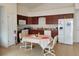 Kitchen features dark wood cabinets, a white refrigerator, and a breakfast table at 332 David Walker Dr # J-2, Tavares, FL 32778
