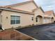Tan stucco exterior of condo building with attached garage and brick walkway at 332 David Walker Dr # J-2, Tavares, FL 32778