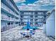 Community pool with patio furniture and building view at 3700 S Atlantic Ave # 407, New Smyrna Beach, FL 32169