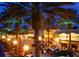 Night view of a vibrant street with palm trees and illuminated buildings at 3700 S Atlantic Ave # 407, New Smyrna Beach, FL 32169