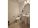 Clean bathroom with pedestal sink, toilet, and round mirror at 13880 Arclid St, Orlando, FL 32832