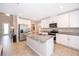 Modern kitchen with white cabinets, granite countertops, and stainless steel appliances at 2370 Brassie Ct, Winter Haven, FL 33884