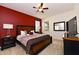 Bedroom with king bed and red accent wall at 401 Cabello Dr, Davenport, FL 33837