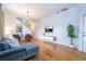 Bright living room with hardwood floors, sectional sofa, and a large TV at 2669 Santosh Cv, Kissimmee, FL 34746