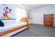 Bright bedroom with a twin bed, Mickey Mouse wall art, and a dresser at 2669 Santosh Cv, Kissimmee, FL 34746