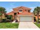 Two-story house with tile roof, two-car garage, and landscaped yard at 112 Paloma Dr, Davenport, FL 33837